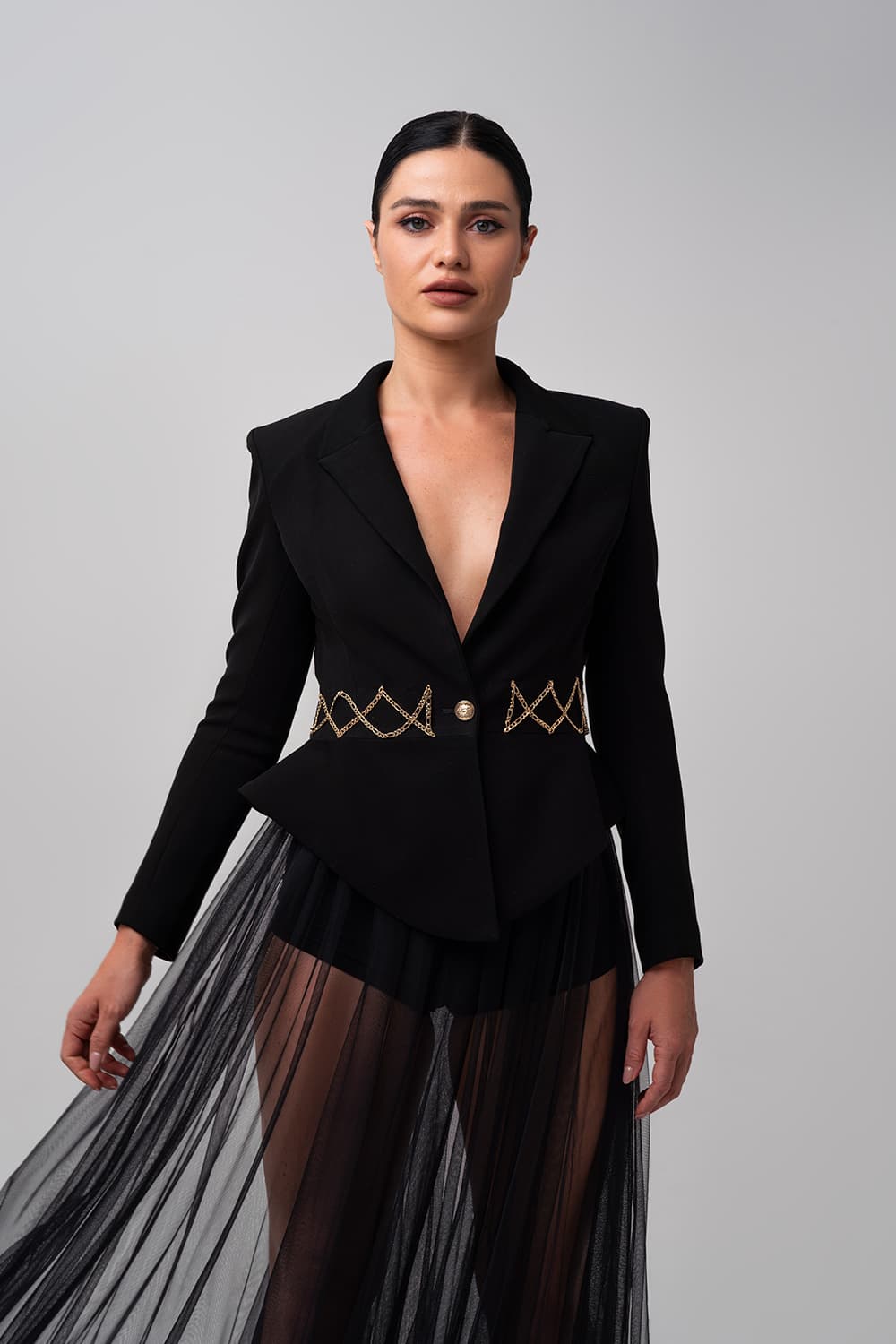Tailored black jacket, detail of the chain-trimmed waist