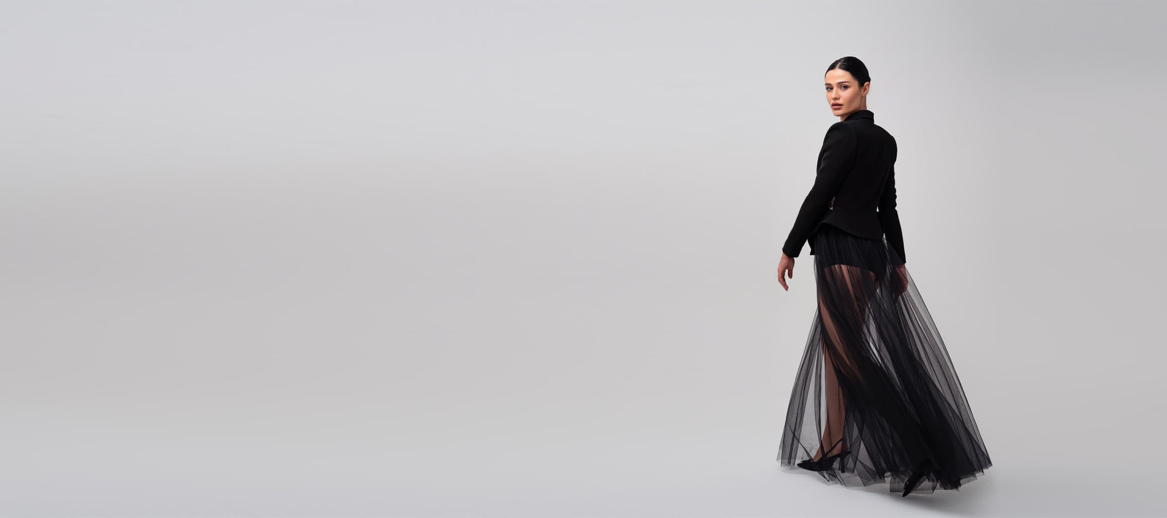 Model in a tailored black jacket and tulle skirt