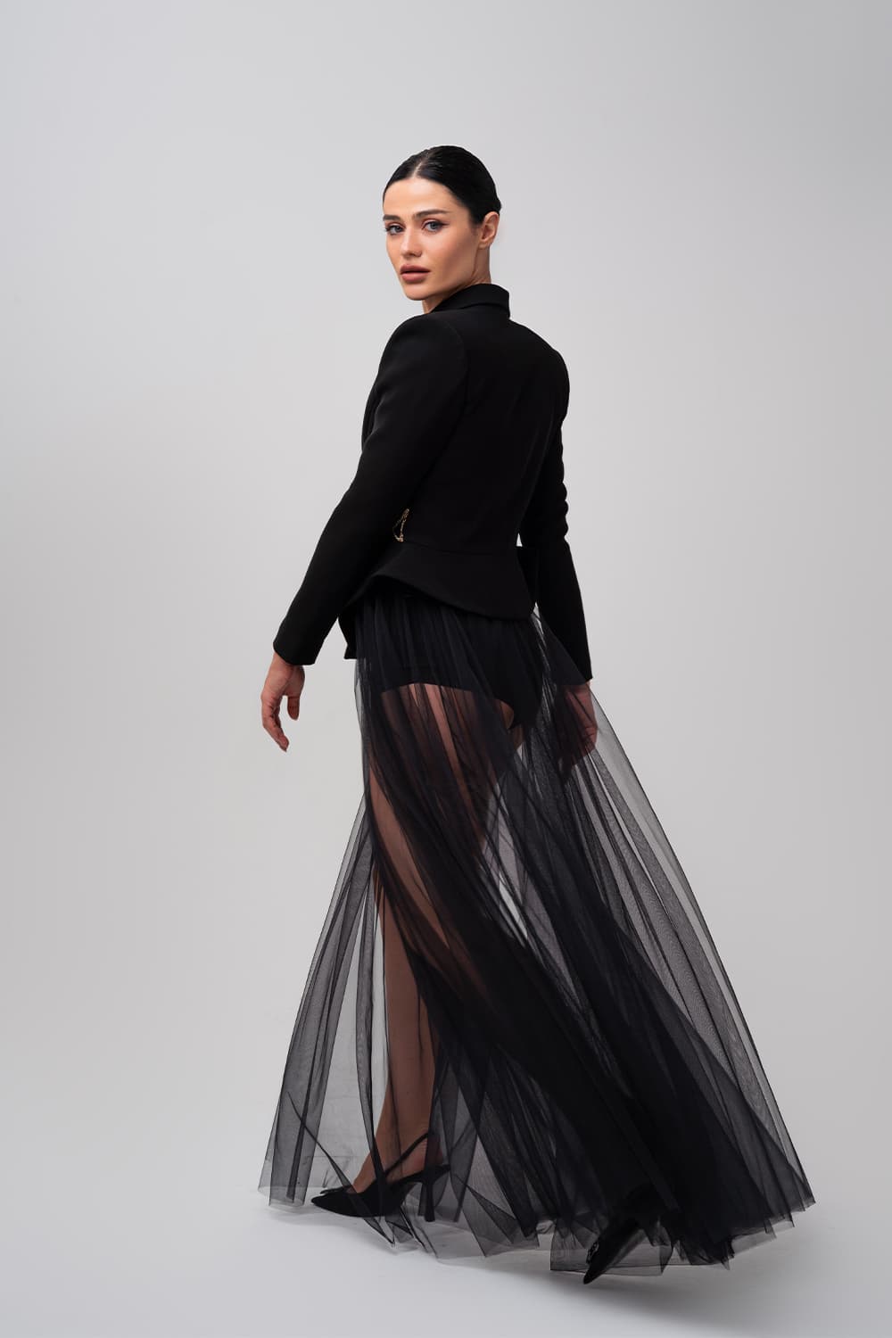Tailored black jacket over a tulle maxi skirt, back view